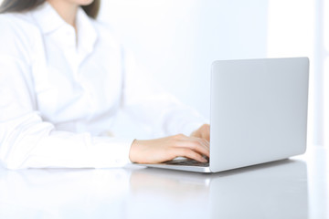 Close-up of business woman hands typing on laptop computer. Secretary at work in office