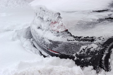 Back of the car covered with snow during a snowstorm