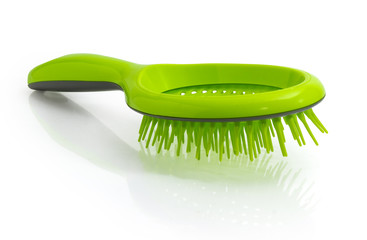 Hairbrush with plastic bristles on a white reflective surface