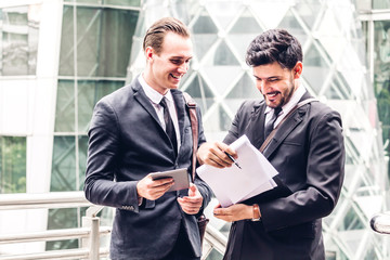 Image two business partners in black elegant suit talking and working together while discussing new strategy at city.Business and startup idea concept