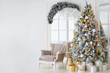 Holiday decorated room with Christmas tree and armchair.