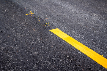 Asphalt road surface with yellow line