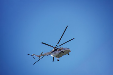Fototapeta na wymiar Helicopter in flight against a cloudless sky