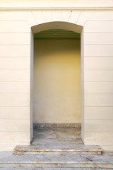 European style building in weathered yellow color wall arch entrance with white marble floor