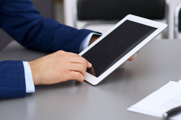 Businessman using touchpad at meeting, closeup of hands
