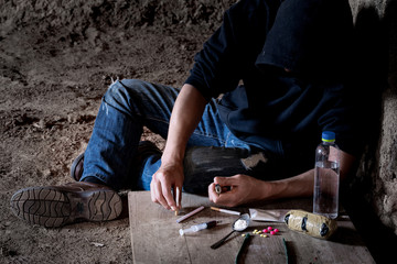 Drug abuse concept, overdose male drug addict hand, drugs narcotic syringe in hand on the floor