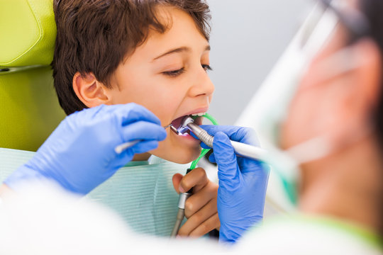Dentist is repairing teeth of a little boy. 