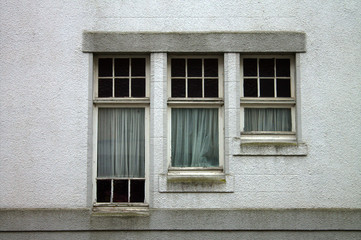 The windows of the old house are wooden frames, curtains, muddy dirty glass.
