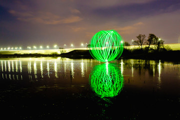 Futuristic glowing sphere reflected on the river surface