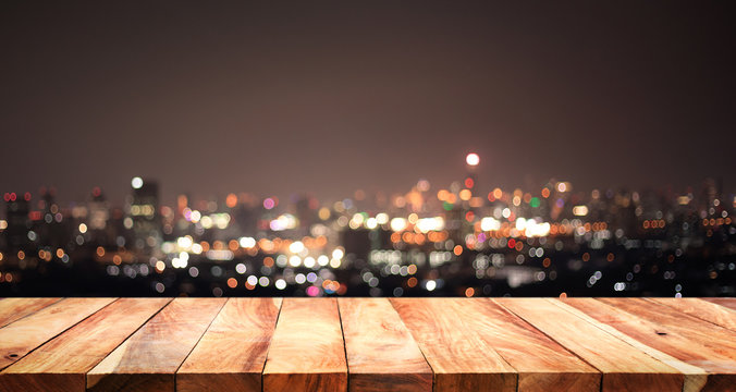 Empty of white wood table top on blur night town,cityscape backgrounds.For montage product display or key visual