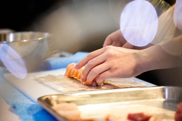 Fototapeta na wymiar chef hands preparing japanese food, chef making sushi, Preparing Sushi roll