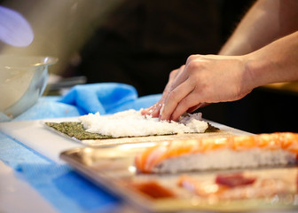 Obraz na płótnie Canvas chef hands preparing japanese food, chef making sushi, Preparing Sushi roll