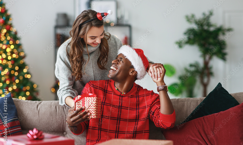 Wall mural happy couple opening presents on christmas morning