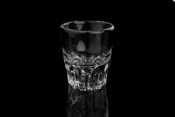 Single whiskey vodka shot glass on black background with reflections and refractions. 3D render