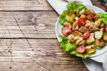 Stewed pieces of chicken with vegetables on a plate.