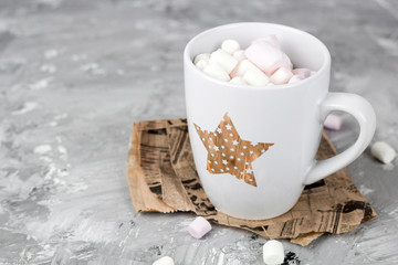 cute cup with marshmallows on a gray grunge concrete background