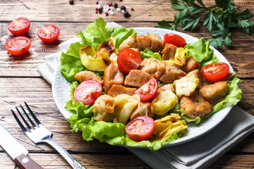 Stewed pieces of chicken with vegetables on a plate.