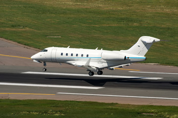Fototapeta na wymiar White modern private jet landing at airport