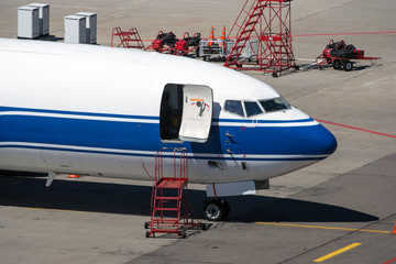 Modern twin engine cargo airplane standing on parking place at ground maintenance at International airport.