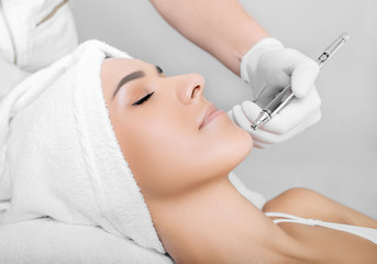 face of beautiful woman while procedure jet peeling, facial treatment