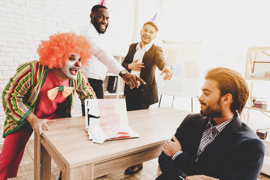 Young Man in Clown Costume on Meeting in Office.