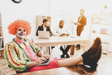 Young Man in Clown Costume on Meeting in Office.