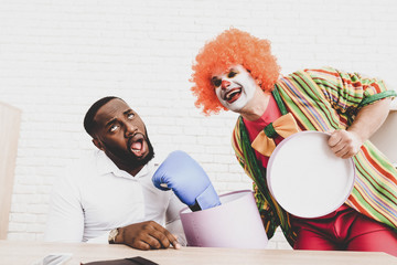 Young Man in Clown Costume on Meeting in Office.