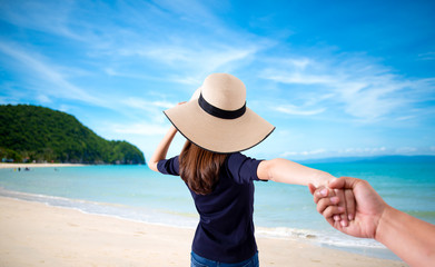 Fototapeta na wymiar woman holding hand of her husband while running together on the beach