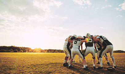 American football players in a huddle during practice - Powered by Adobe