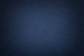 Texture of old navy blue paper background, closeup. Structure of dense cardboard.