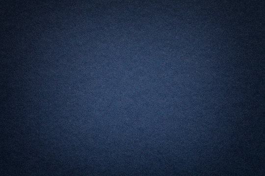 Texture of old navy blue paper background, closeup. Structure of dense cardboard.
