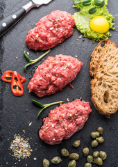 Steak tartare served with capers, pickled cucumbers and chopped onion.