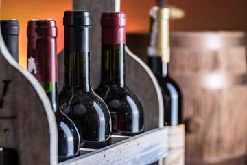 Tuinposter Wine bottles in wooden crate and oak wine keg. © volff