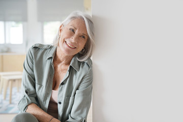  Beautiful relaxed elderly woman sitting at home - obrazy, fototapety, plakaty