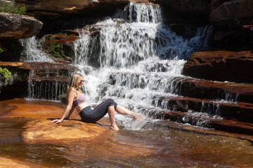Female splashing her feet in cascading waterfall