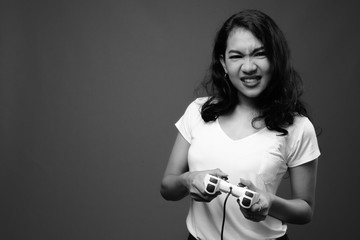 Beautiful Asian woman playing games and holding game controller
