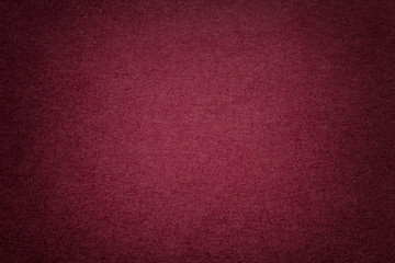 Texture of old dark red paper background, closeup. Structure of dense cardboard.