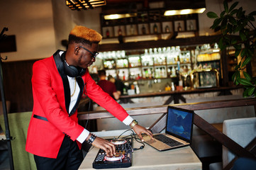Fashion african american man model DJ at red suit with dj controller.