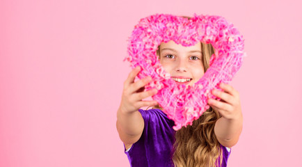 Obraz na płótnie Canvas Celebrate valentines day. Love holiday decor. Love concept. Girl cute child show heart shaped decor. Symbol of love. Kid adorable girl with long hair happy face show heart to you. Look in heart part