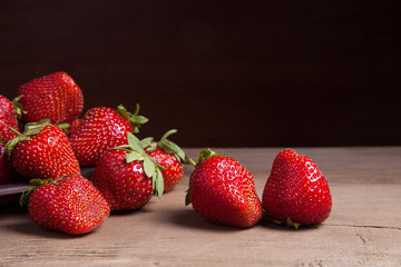 Strawberry fresh ripe sweet berry in clay plate on wooden background.
