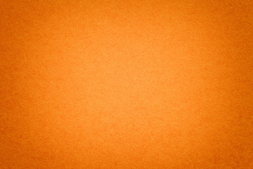 Texture of old orange paper background, closeup. Structure of dense cardboard.