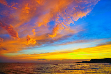 Fototapety  Złote chmury o zachodzie słońca nad morzem.