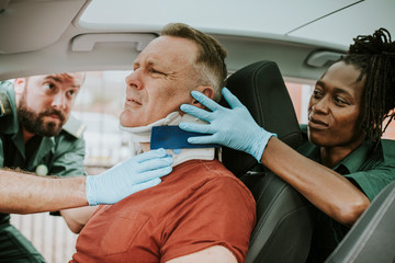 Paramedic placing a cervical collar to an injured man from car accident - obrazy, fototapety, plakaty