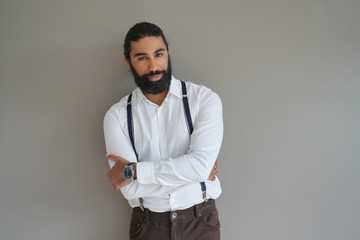 Hipster man with suspenders standing on background, isolated