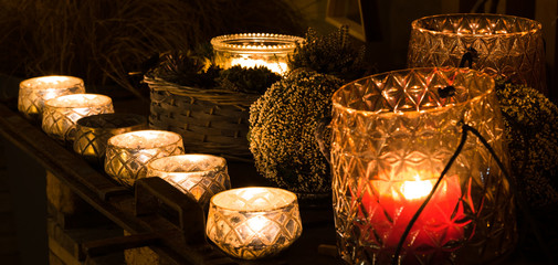 decorative and festive Christmas holiday arrangement with glasses and candles and assorted decorative articles at night