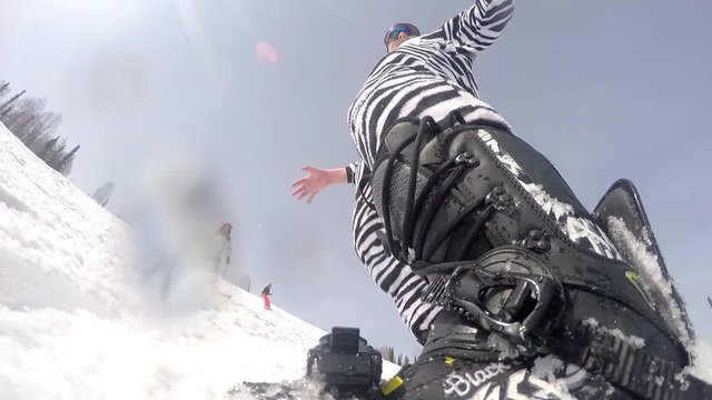 Snowboarder wears zebra suit downhill rides through mountain and the sun's rays. The view action cameras. 1920x1080