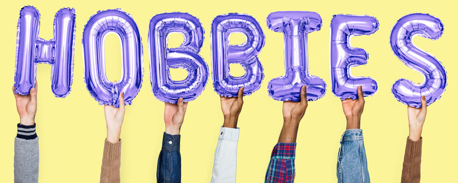 Hands holding hobbies word in balloon letters