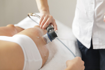 Close-up of beautiful  tanned woman belly receiving massage in spa salon