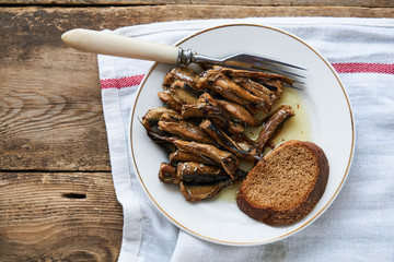 Canned sprats with oil and bread on a plate                              