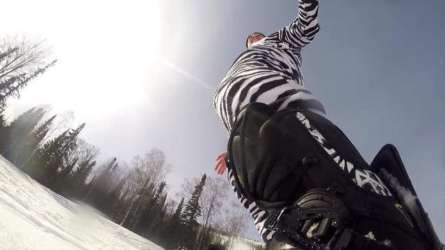 Snowboarder downhill rides through mountain and the sun's rays. The view action cameras. 1920x1080